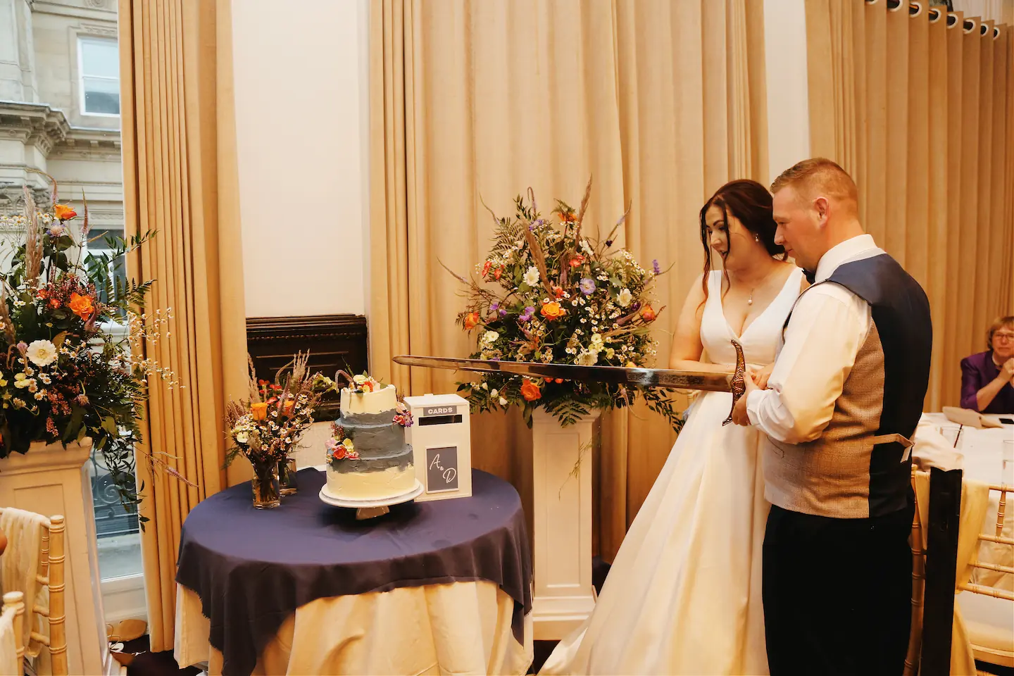 Moved Wedding ceremony Entrance pedestal flower arrangement on plinth to behind cake table